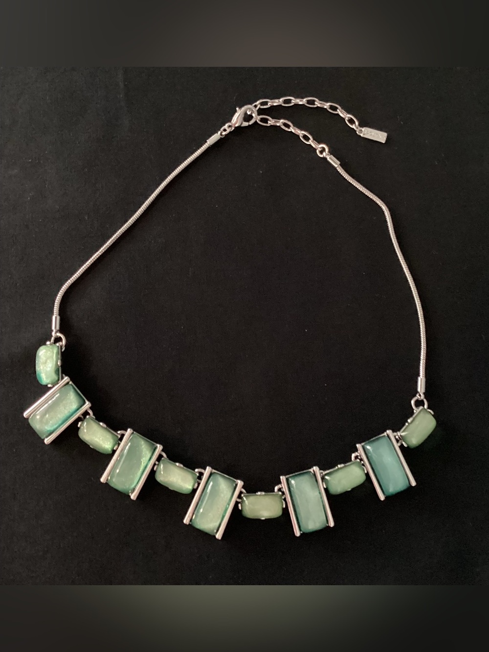 Spoutnik silvertone necklace featuring rectangular green glass stones.